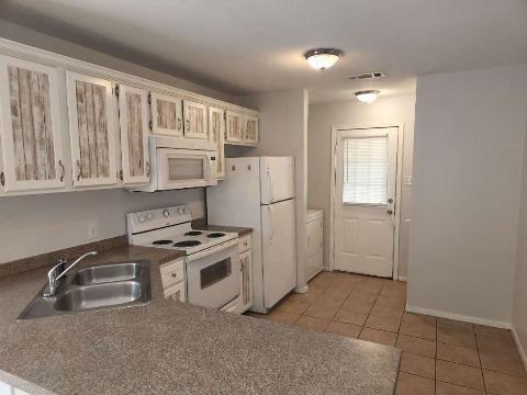 2203 Monroe Street, Unit B Commerce, TX 75428 - Photo 2 of 6 a kitchen with stainless steel appliances granite countertop a stove a refrigerator and a sink