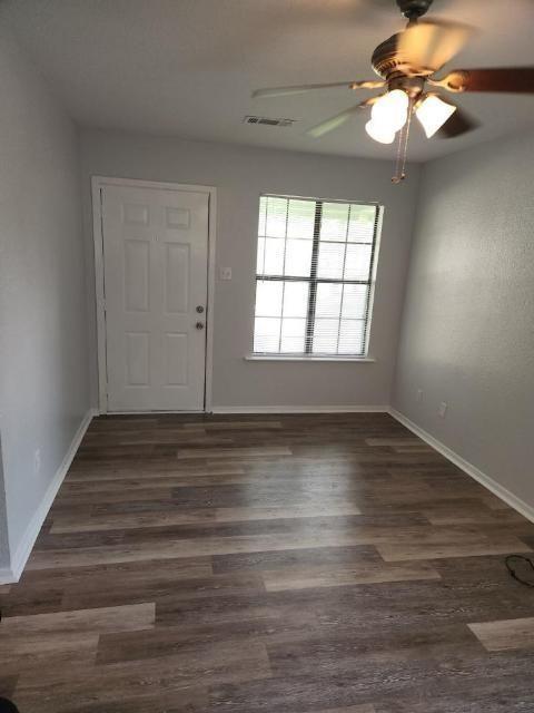 2203 Monroe Street, Unit B Commerce, TX 75428 - Photo 6 of 6 wooden floor in an empty room with a window