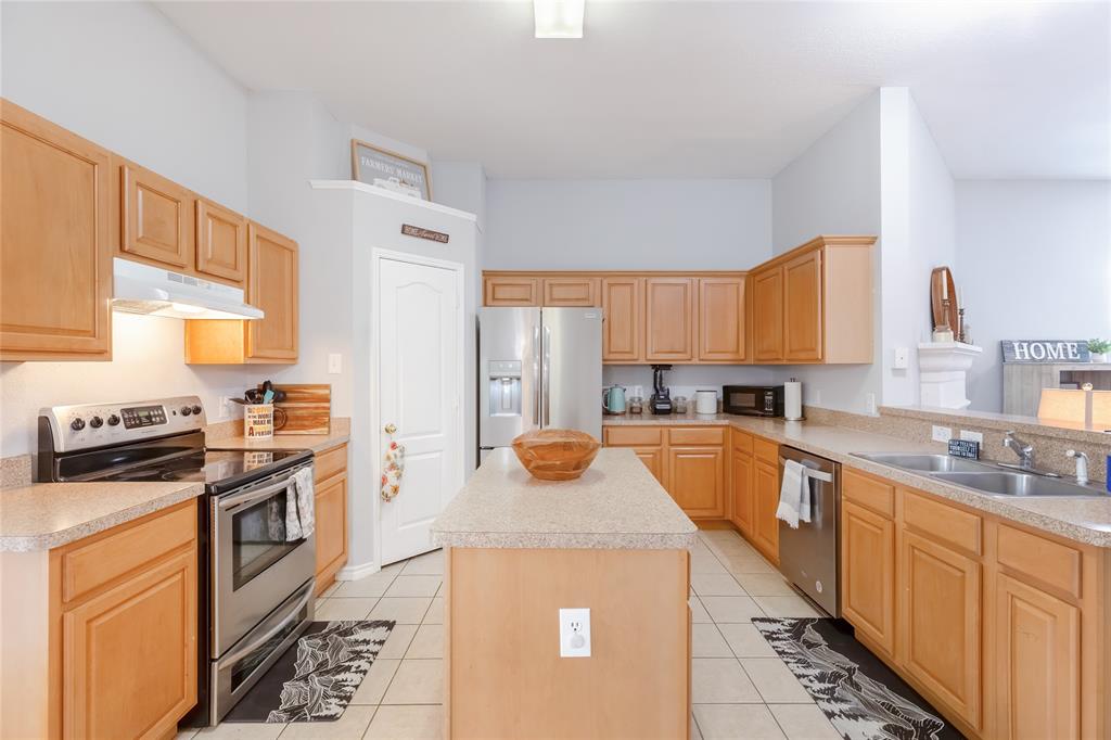 3729 Cook Court Fort Worth, TX 76244 - Photo 8 of 24 a kitchen with stainless steel appliances a stove a sink cabinets and a window