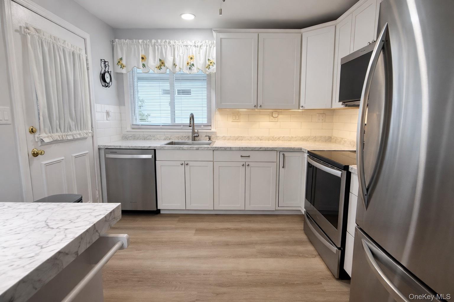 2 Bedford Court Ridge, NY 11961 - Photo 3 of 12 a kitchen with stainless steel appliances granite countertop a refrigerator and a sink
