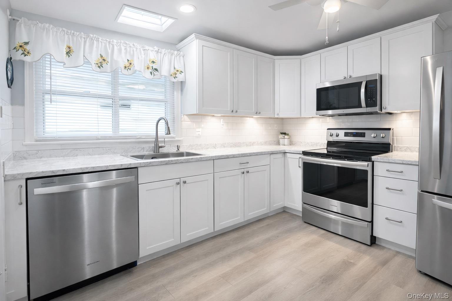 2 Bedford Court Ridge, NY 11961 - Photo 4 of 12 a kitchen with appliances cabinets and a sink