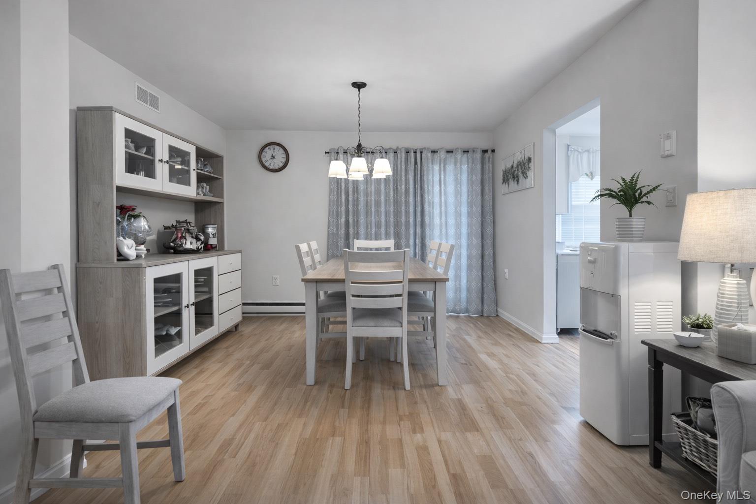 2 Bedford Court Ridge, NY 11961 - Photo 5 of 12 a dining room with furniture a chandelier and wooden floor