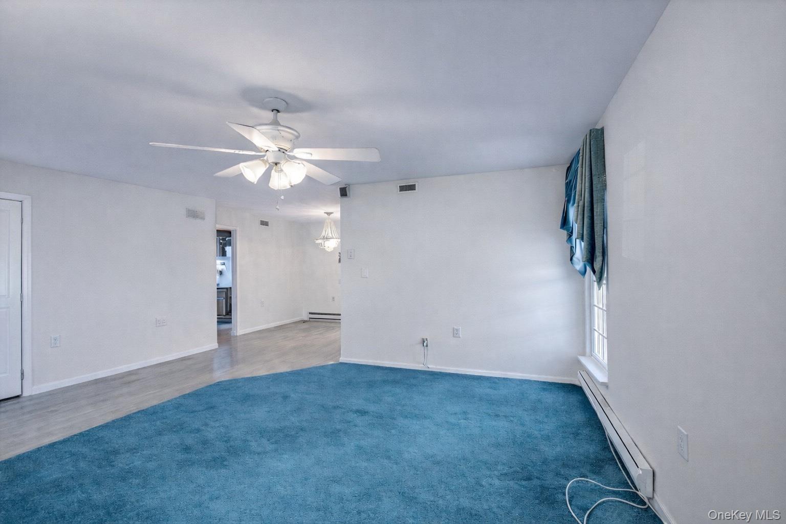 2 Bedford Court Ridge, NY 11961 - Photo 6 of 12 an empty room with chandelier fan and windows