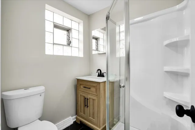 a bathroom with a toilet a sink and a window