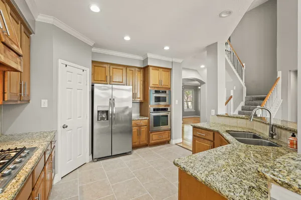 a kitchen with stainless steel appliances granite countertop a sink stove and refrigerator
