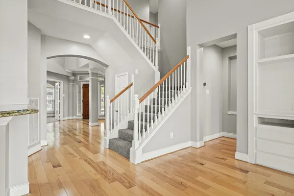 a view of a hallway with wooden floor and staircase