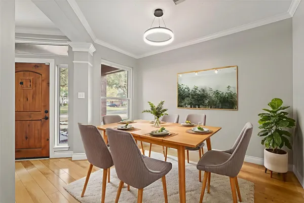 a dining room with furniture potted plants and wooden floor