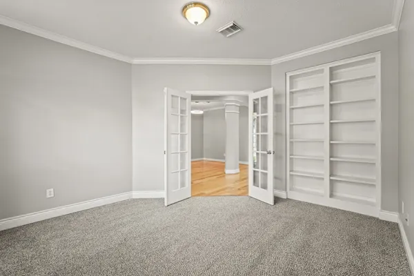 a view of an empty room with cabinet and a window