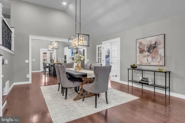 a kitchen with stainless steel appliances granite countertop a stove a sink dishwasher and white cabinets with wooden floor