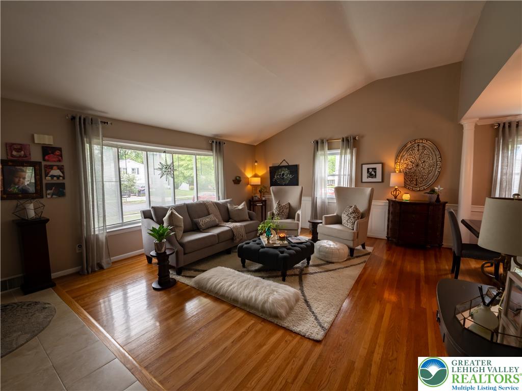 2087 Hopewell Road Bethlehem, PA 18017 - Photo 8 of 38 Natural light floods this inviting living area, showcasing its rich hardwood flooring and vaulted ceilings.