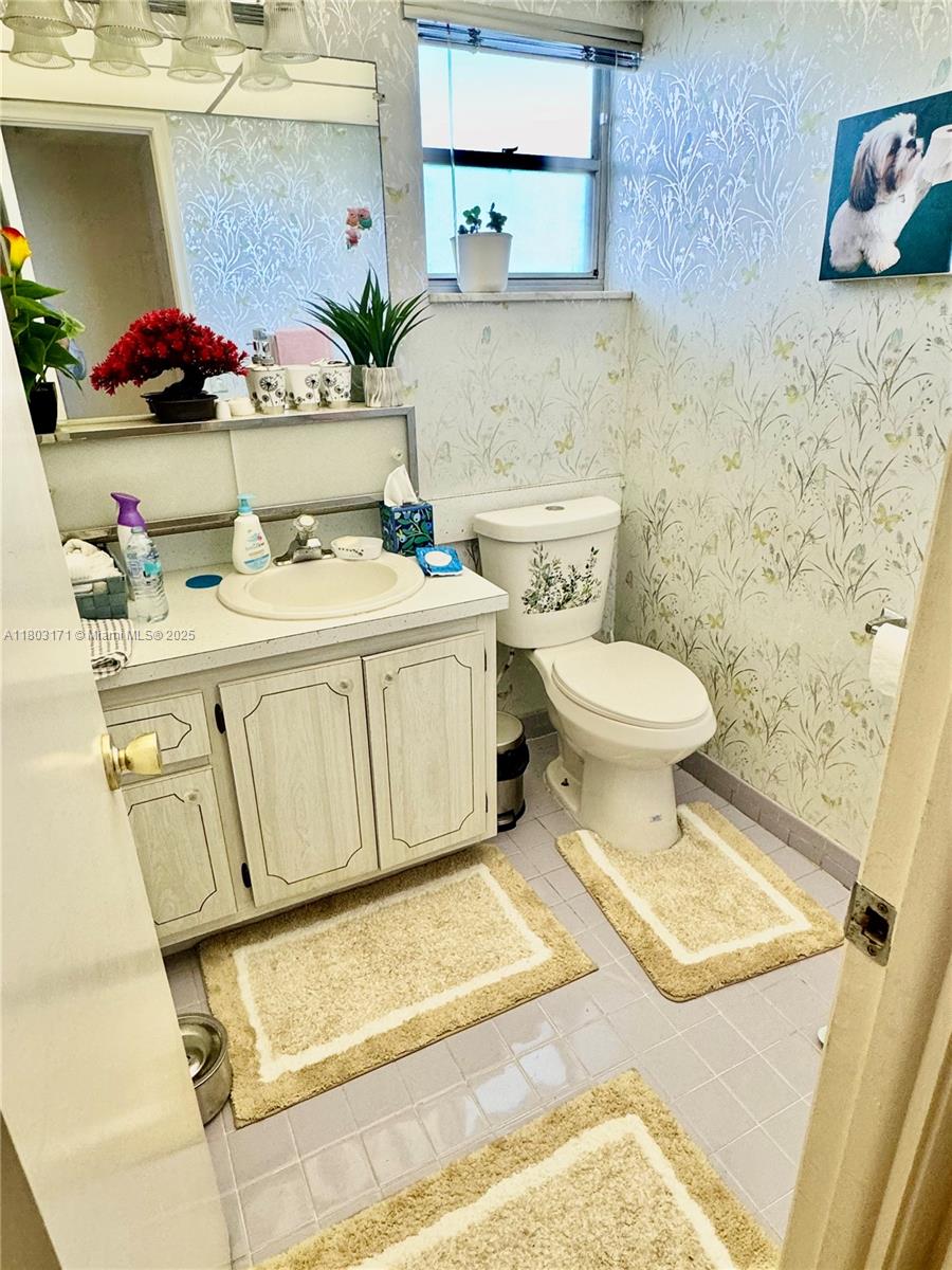 619 Northeast 14th Avenue, Unit 503 Hallandale Beach, FL 33009 - Photo 6 of 8 a bathroom with a sink toilet and vanity
