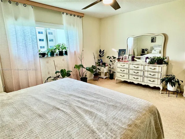 a bedroom with a bed and a mirror on the dresser