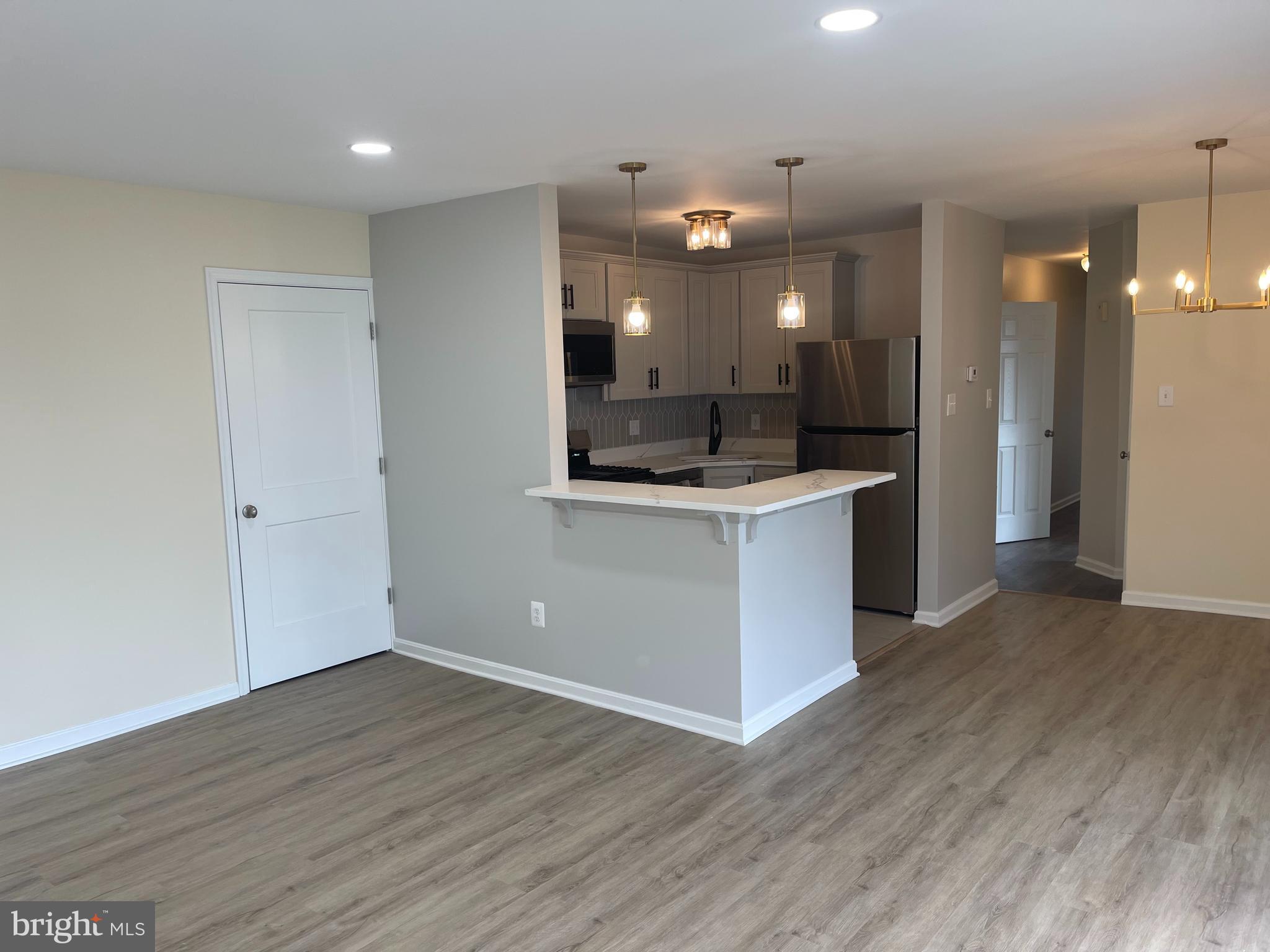 3142 Brinkley Road, Unit 6304 Temple Hills, MD 20748 - Photo 11 of 15 an open kitchen with a sink and a refrigerator