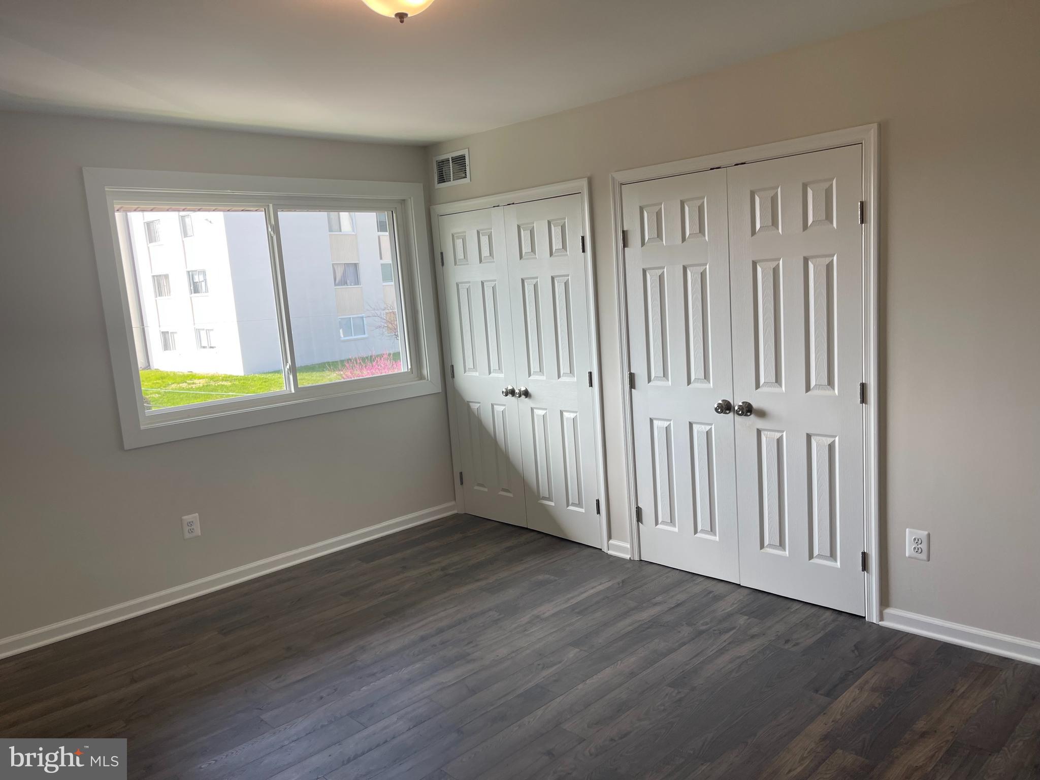 3142 Brinkley Road, Unit 6304 Temple Hills, MD 20748 - Photo 8 of 15 an empty room with wooden floor and windows