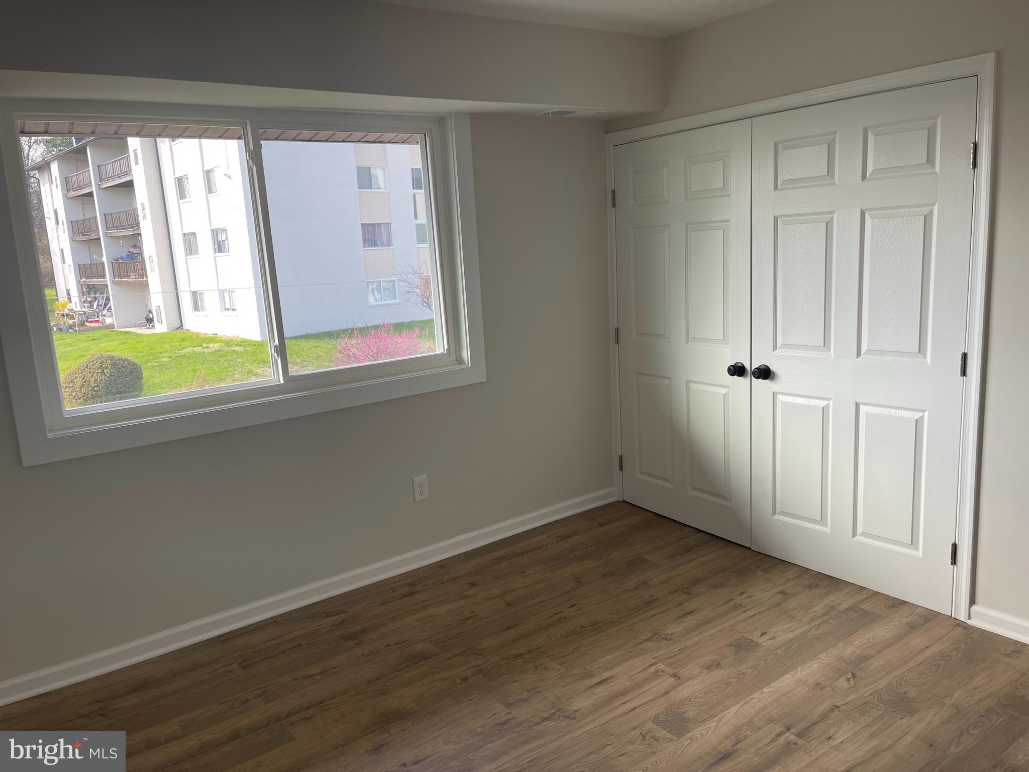 3142 Brinkley Road, Unit 6304 Temple Hills, MD 20748 - Photo 9 of 15 an empty room with wooden floor and windows