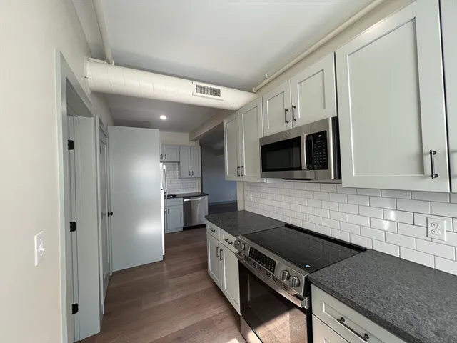 a kitchen with stainless steel appliances granite countertop a stove a microwave and a sink