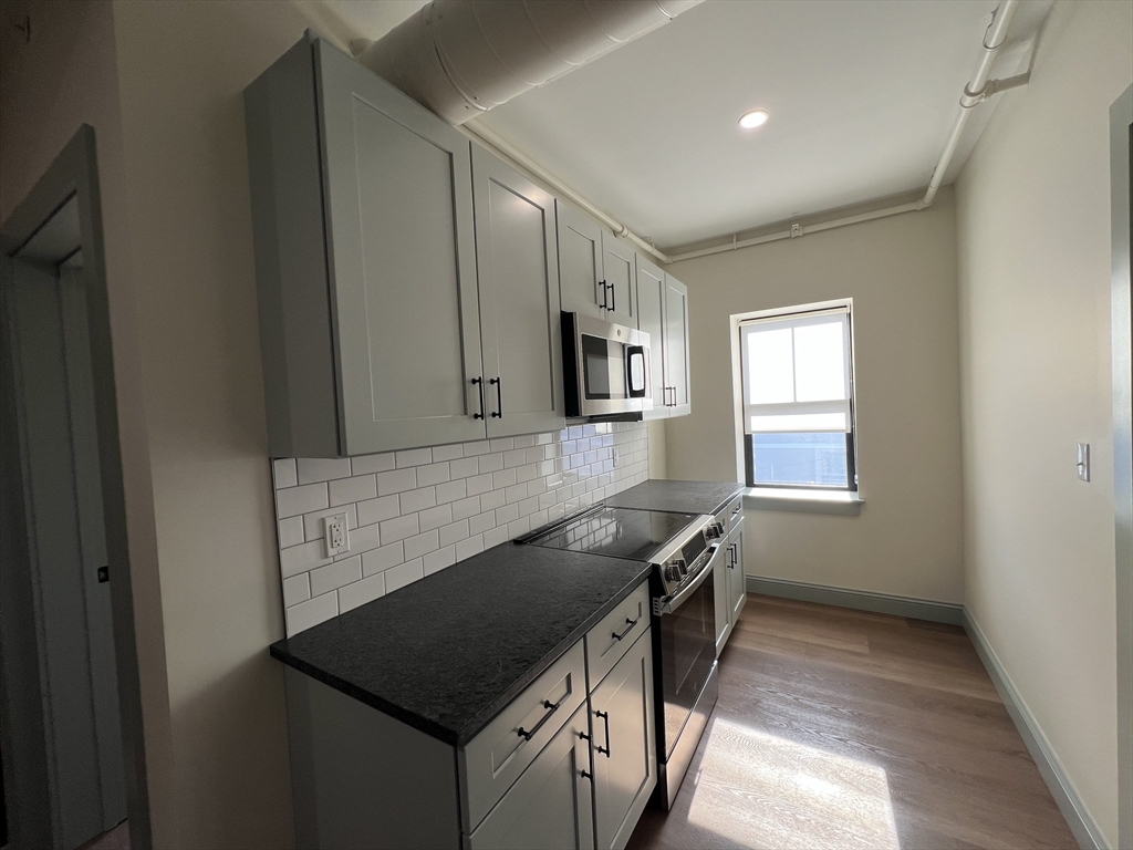 160 Seabury Street, Unit 15 Fall River, MA 02720 - Photo 5 of 10 a kitchen with granite countertop a sink and a stove
