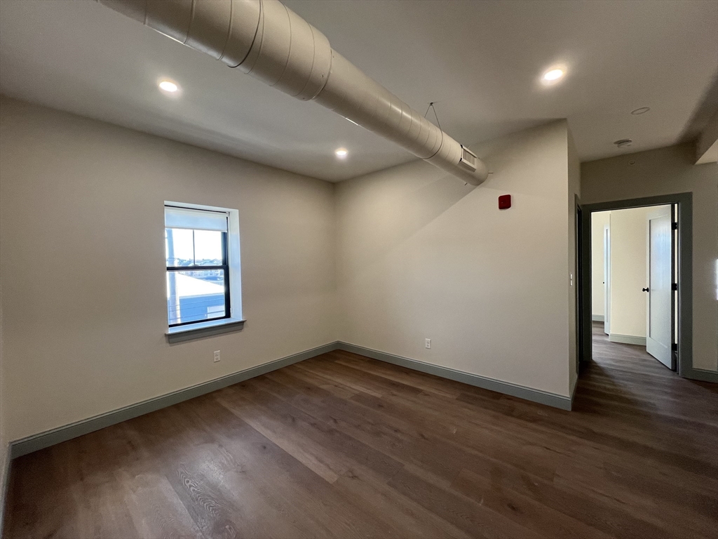 160 Seabury Street, Unit 15 Fall River, MA 02720 - Photo 6 of 10 an empty room with wooden floor and windows