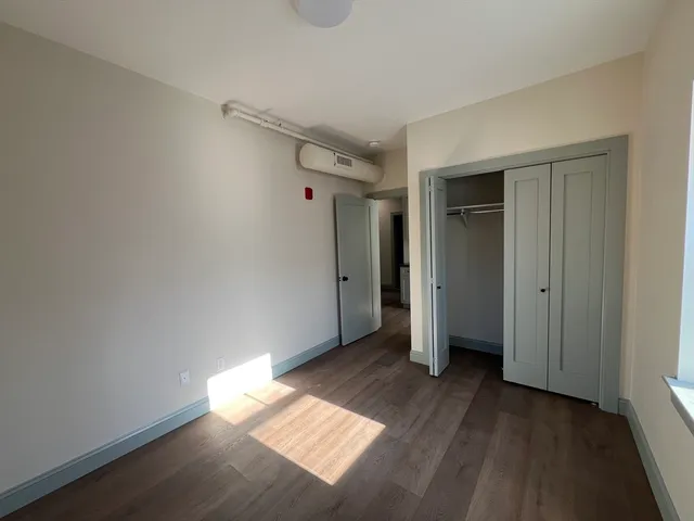 an empty room with wooden floor and closet