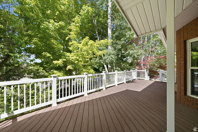 3120 North Apache Way Provo, UT 84604 - Photo 52 of 58 Expansive outdoor deck featuring wood-finish decking, white railings, a covered patio area, and a brick exterior wall