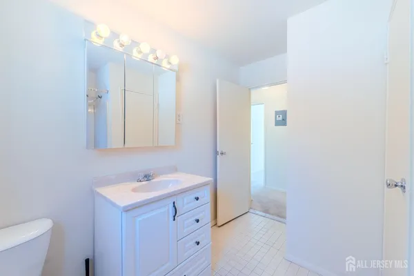 a bathroom with a sink a toilet and a mirror