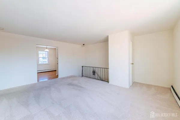 a view of an empty room with a window and stairs