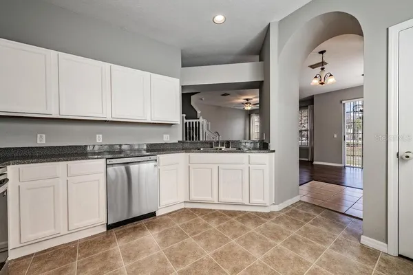 a kitchen with granite countertop a sink and white cabinets