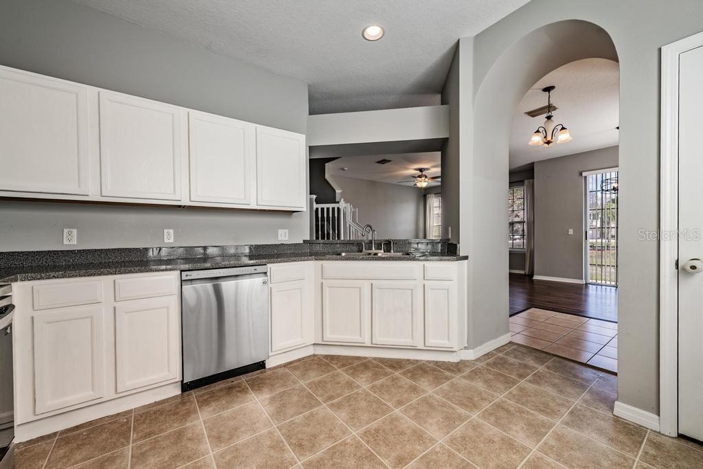8512 Shallow Creek Court New Port Richey, FL 34653 - Photo 15 of 45 a kitchen with granite countertop a sink and white cabinets