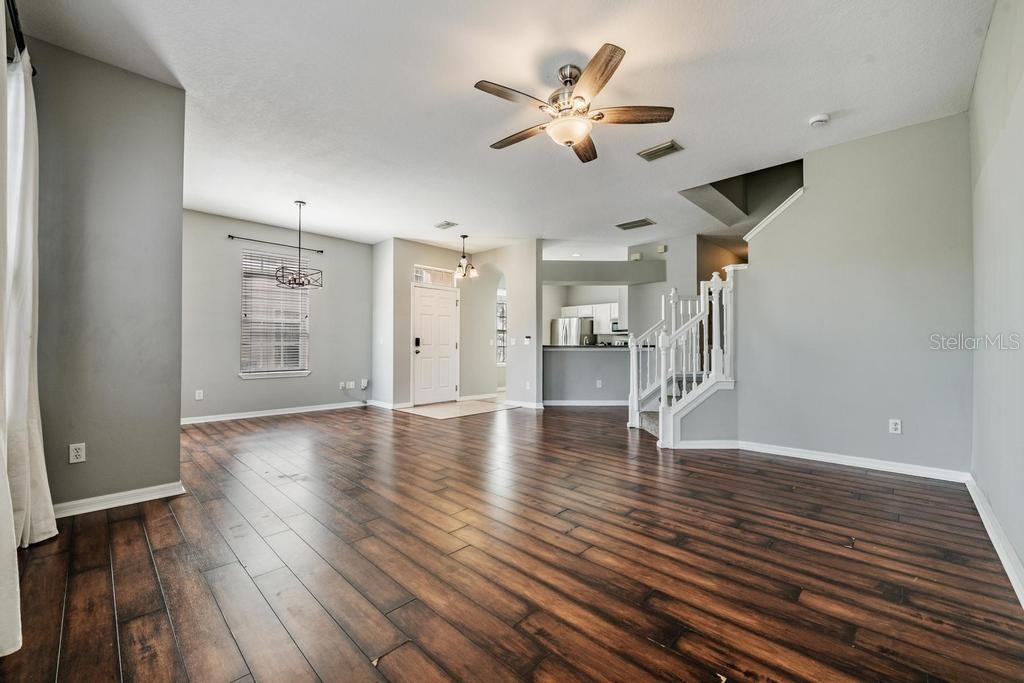 8512 Shallow Creek Court New Port Richey, FL 34653 - Photo 5 of 45 a view of an empty room with wooden floor and a ceiling fan