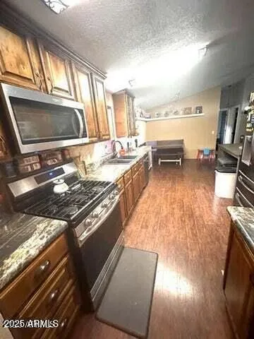 a kitchen with stove and wooden floor