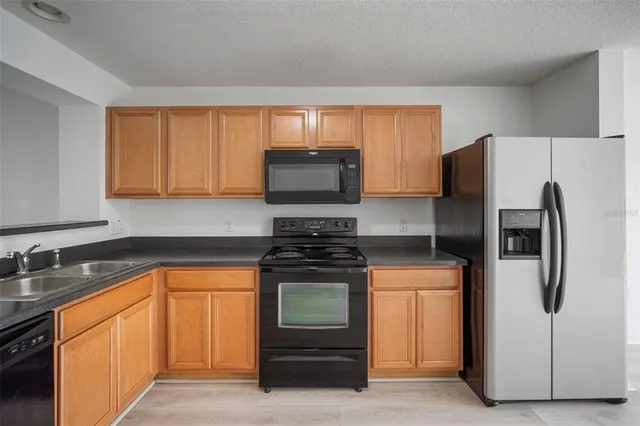 a kitchen with stainless steel appliances granite countertop a refrigerator stove and sink