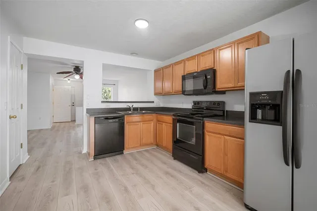 a kitchen with granite countertop a refrigerator stove top oven and sink