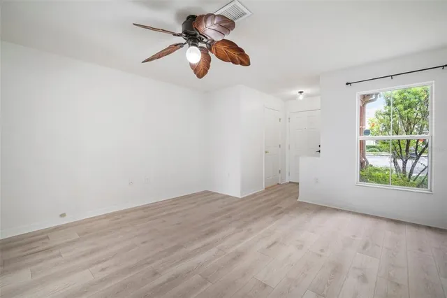 an empty room with windows and fan