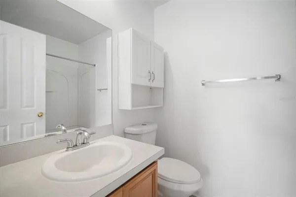 a bathroom with a sink a toilet and a mirror