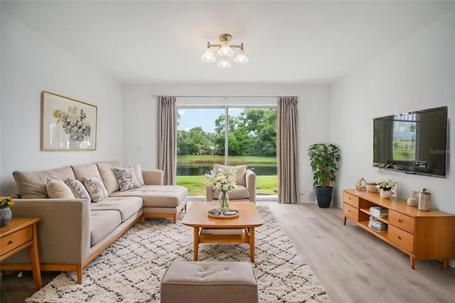 a living room with furniture a flat screen tv and a large window