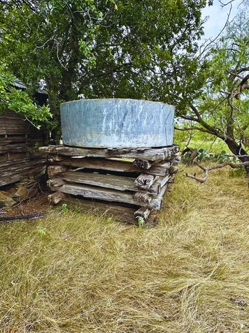 a view of backyard with wooden fence and a large tree