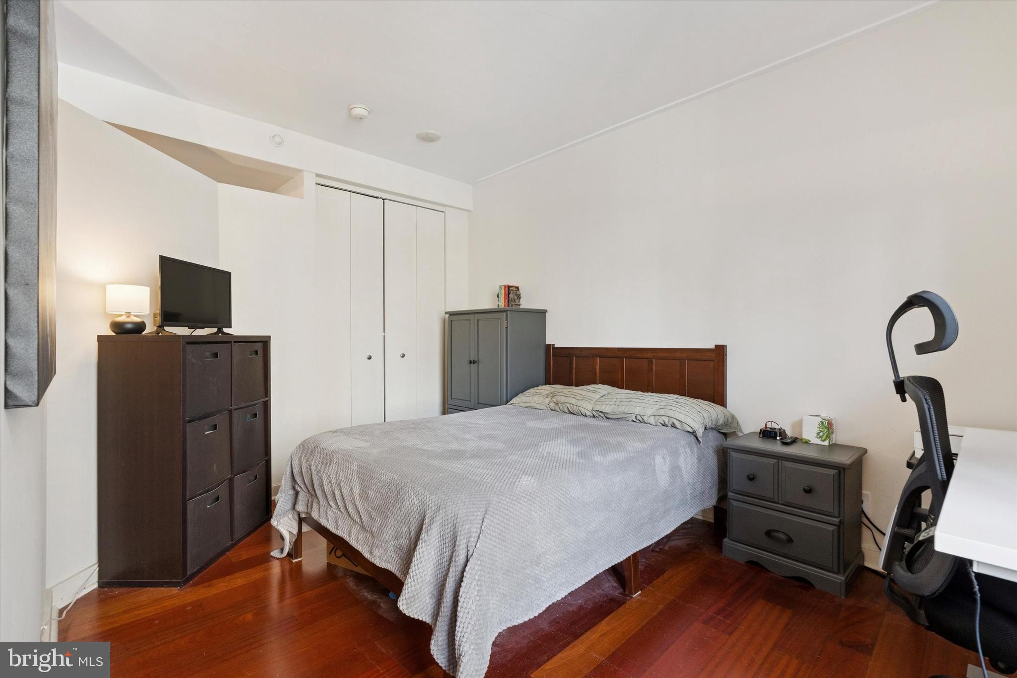 219 South 18th Street, Unit 902 Philadelphia, PA 19103 - Photo 12 of 14 a bedroom with a bed and wooden floor