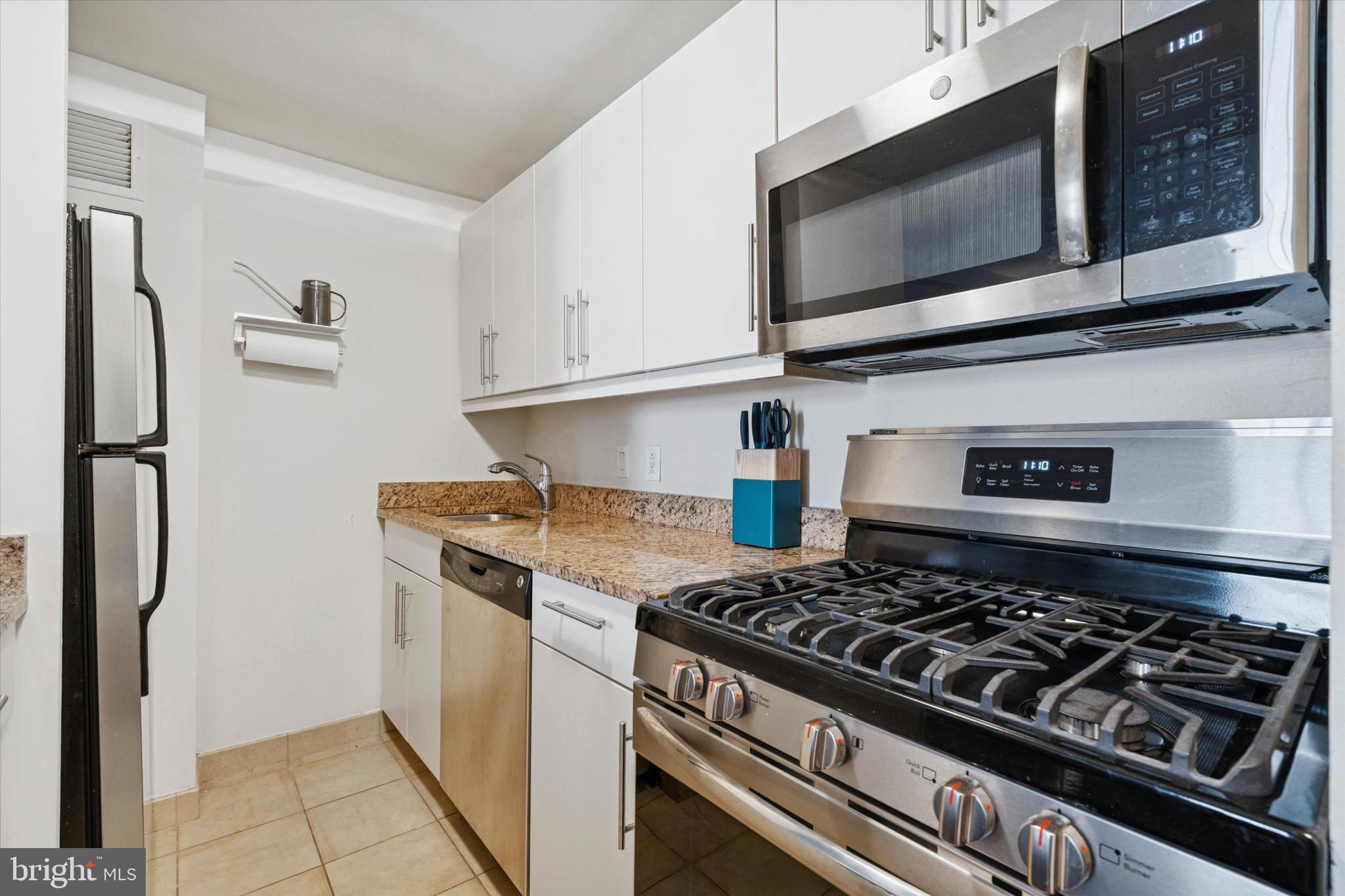 219 South 18th Street, Unit 902 Philadelphia, PA 19103 - Photo 8 of 14 a kitchen with stainless steel appliances granite countertop a stove and a microwave