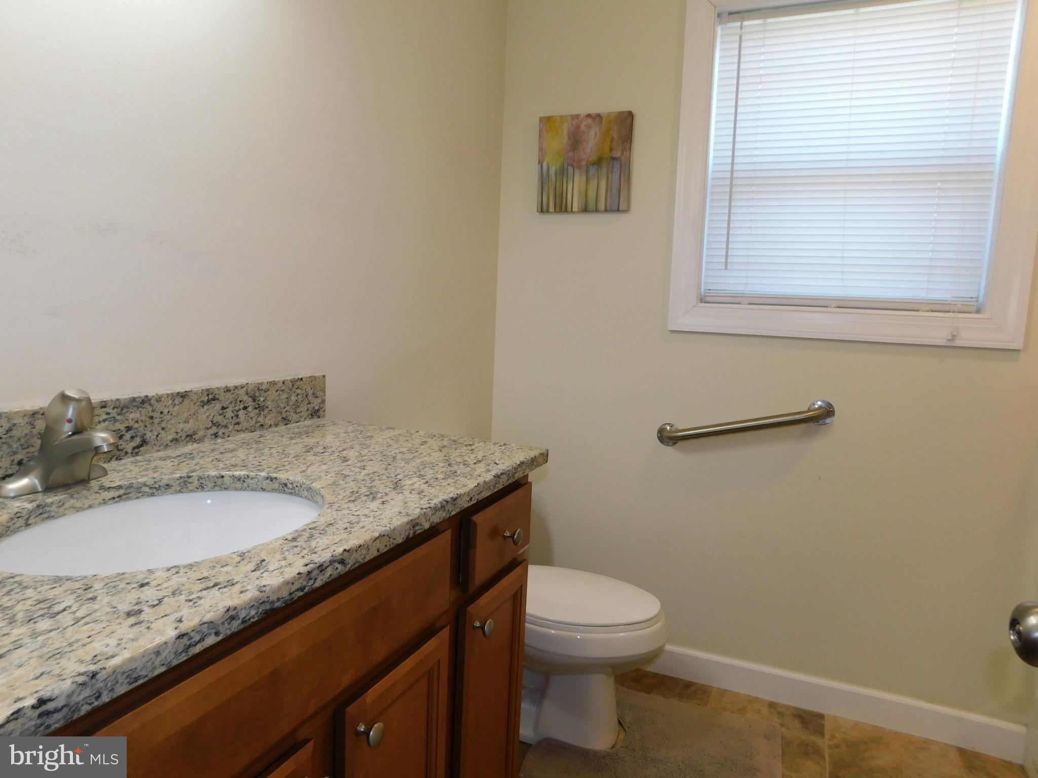 424 Eisenhower Drive Chambersburg, PA 17201 - Photo 23 of 30 a bathroom with a granite countertop sink a toilet and a mirror