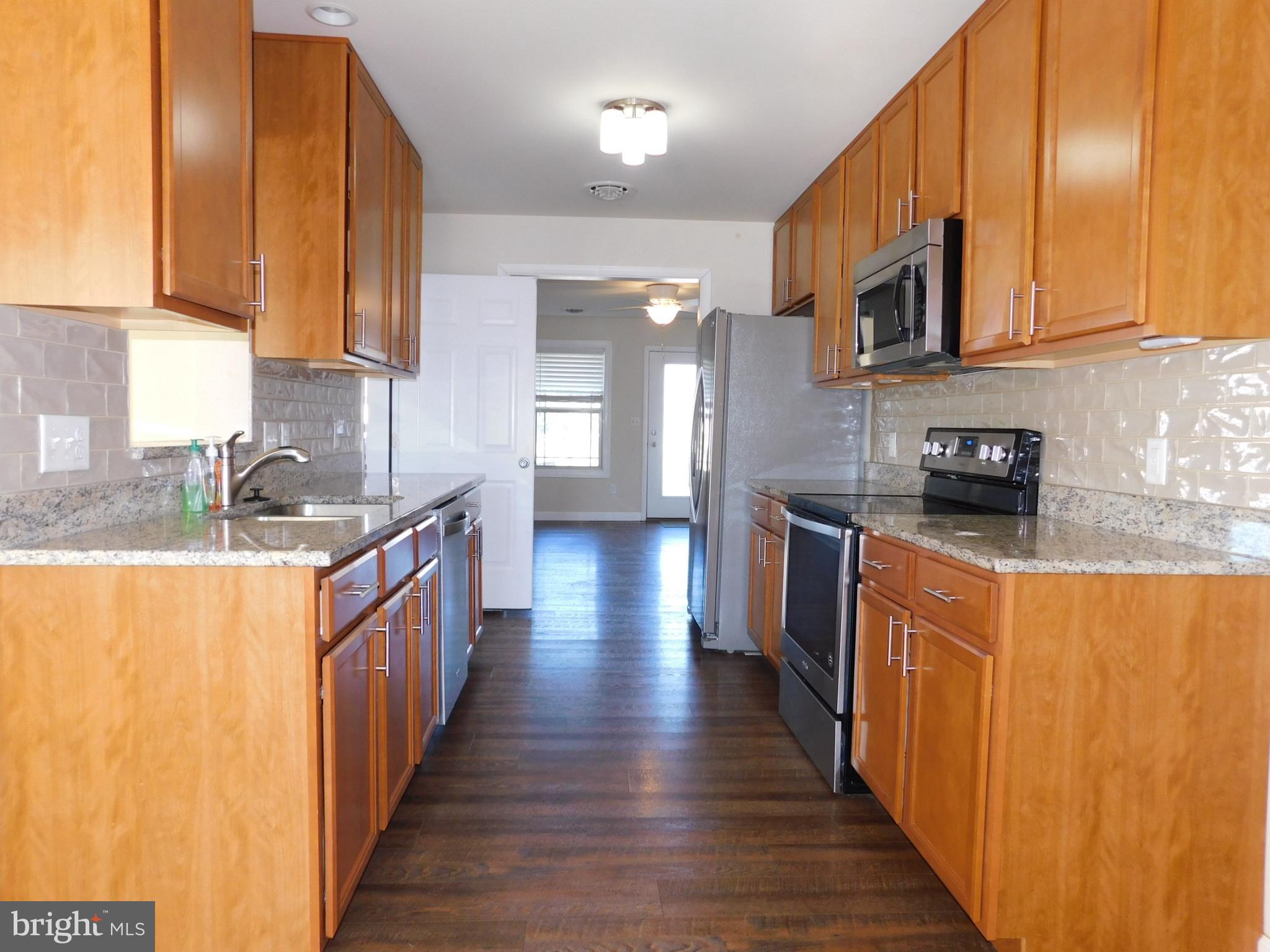424 Eisenhower Drive Chambersburg, PA 17201 - Photo 4 of 30 a kitchen with stainless steel appliances granite countertop wooden cabinets a sink and dishwasher a stove top oven