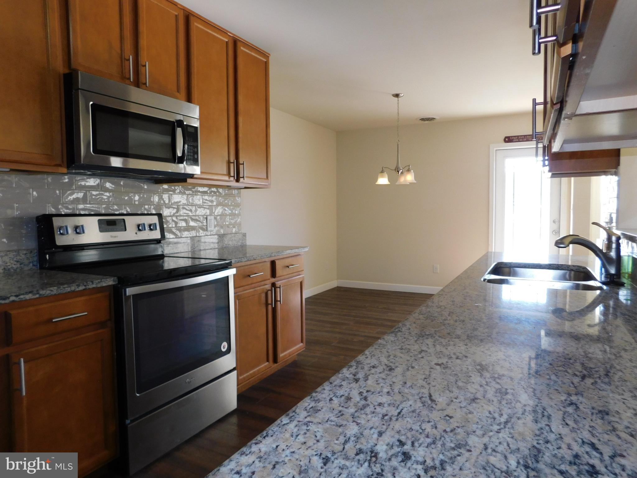 424 Eisenhower Drive Chambersburg, PA 17201 - Photo 8 of 30 a kitchen with stainless steel appliances granite countertop a stove a sink and a microwave