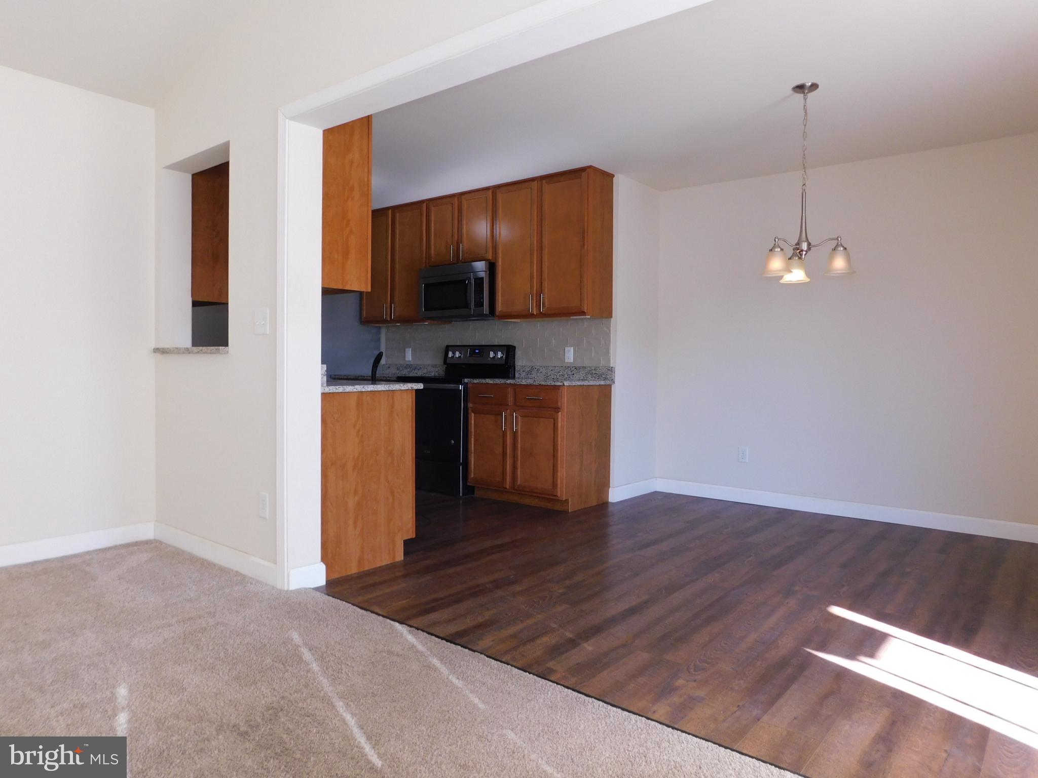 424 Eisenhower Drive Chambersburg, PA 17201 - Photo 9 of 30 a kitchen with wooden floor and a view of living room