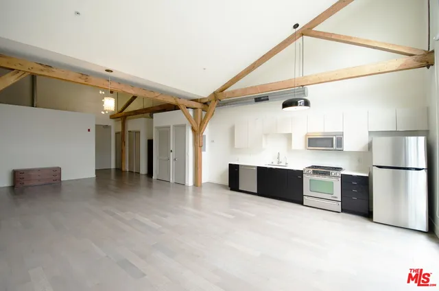 a kitchen with stainless steel appliances granite countertop a refrigerator a sink and a stove