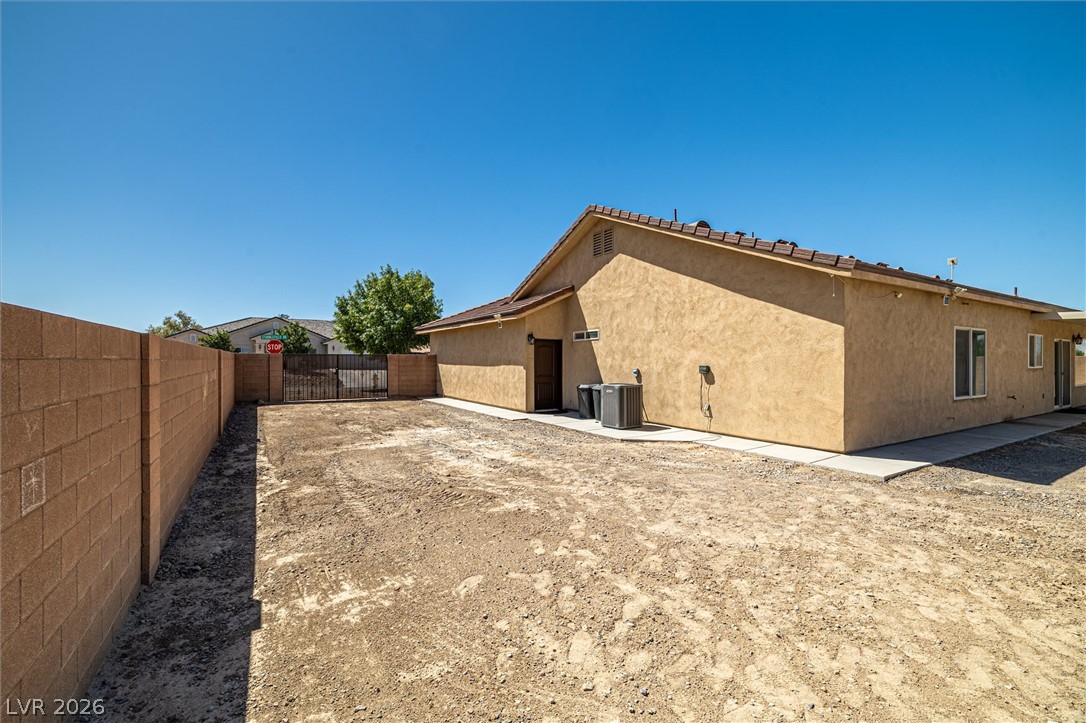 6720 Stubblefield Drive Pahrump, NV 89061 - Photo 37 of 51 A spacious backyard with block fencing and a privacy gate offers ample outdoor potential.
