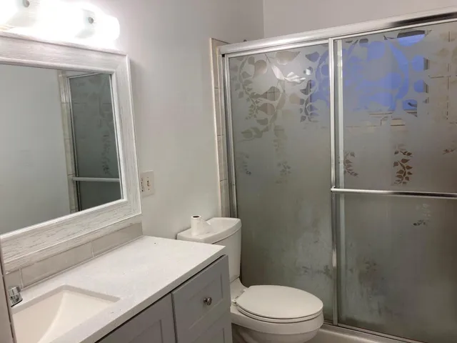 a bathroom with a sink a toilet and shower