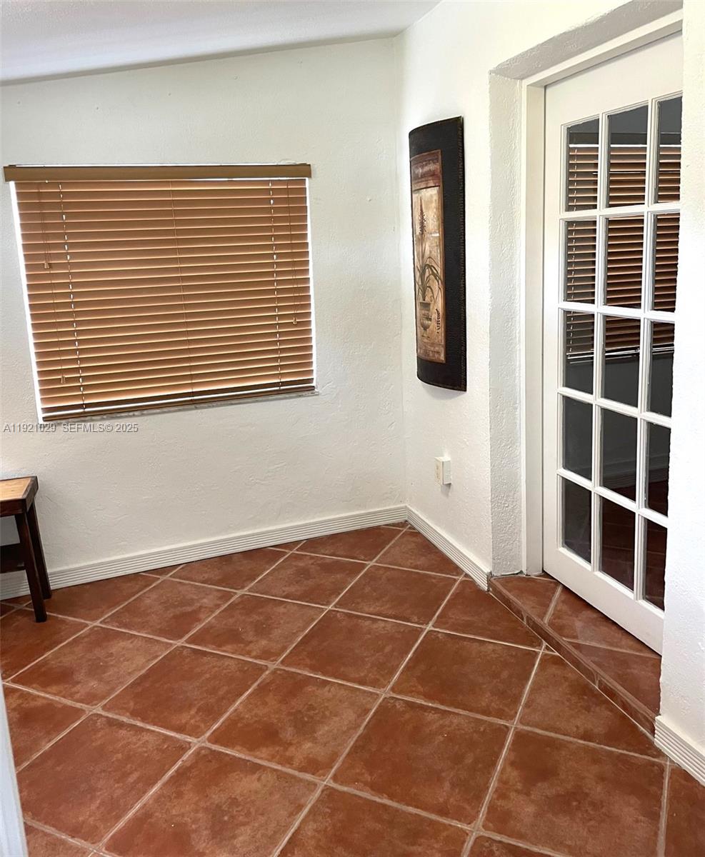 635 Southwest 64th Court Miami, FL 33144 - Photo 13 of 33 a view of an empty room with a window and wooden floor