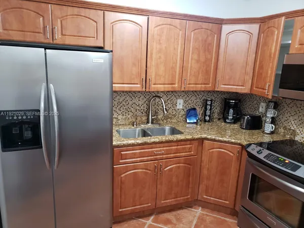 a kitchen with stainless steel appliances granite countertop a refrigerator a stove a sink and dishwasher