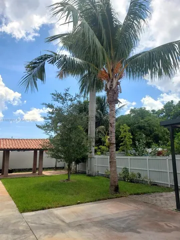 a front view of a house with a garden and trees