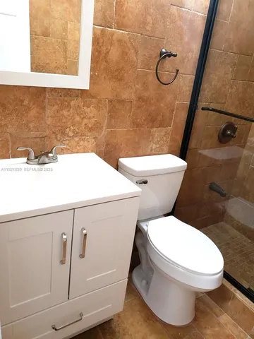 a bathroom with a toilet and a shower