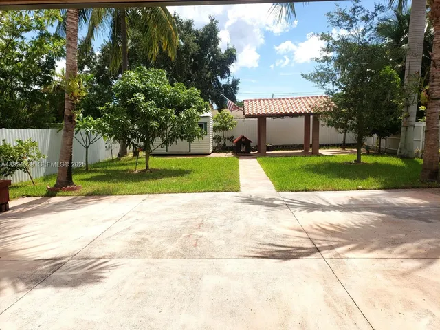 a front view of a house with a yard and large trees